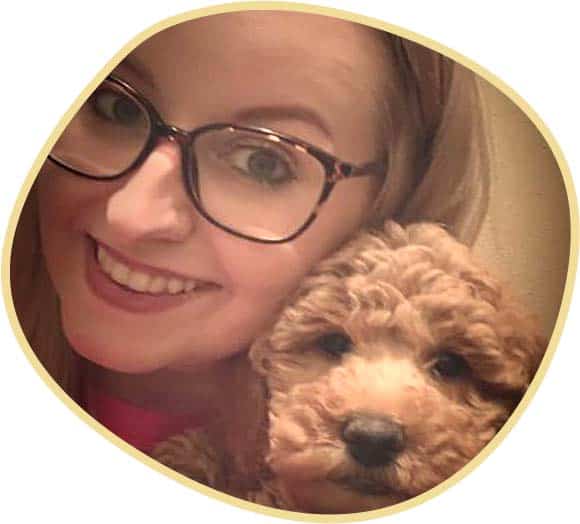 Smiling Cute Goldendoodle puppy with Women Wearing Eyeglasses.